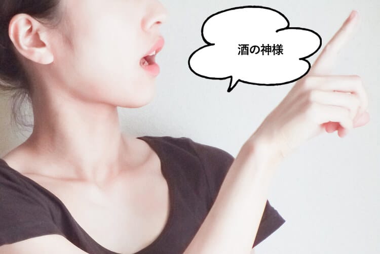 酒の神様と話し指さす女性