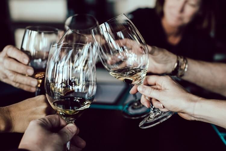 Five people toasting with glasses containing champagne