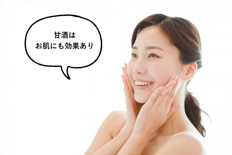 頬を触りながら笑顔で甘酒はお肌にも効果ありと話す女性