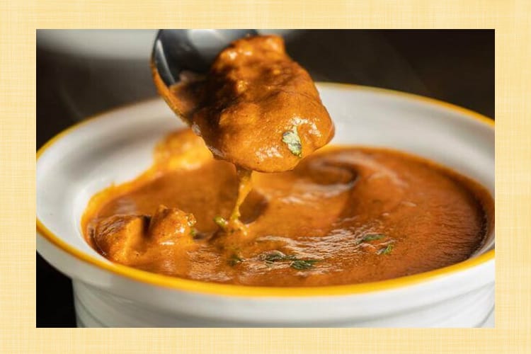 小さな皿に入ったカレーをスプーンですくいあげる様子