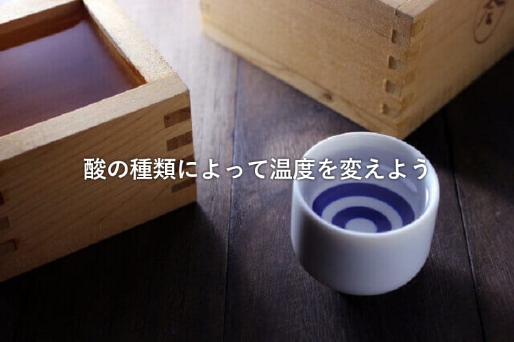 2つの日本酒が入った枡とこちらも日本酒が入ったおちょこ