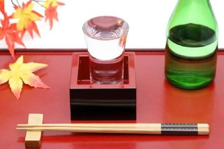 お盆の上に置かれた枡酒と箸