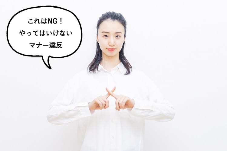 ばつサインをして「これはNG!やってはいけないマナー違反」と話す女性