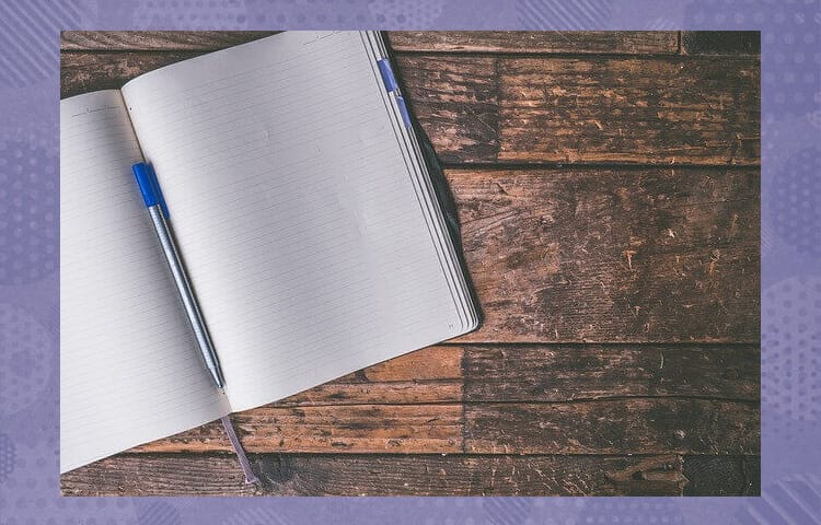 木の板の上に置かれたノートとペン