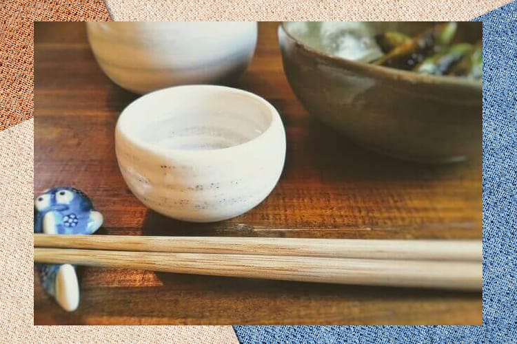 丸くて白いおちょことお惣菜、そして手前に置かれた箸