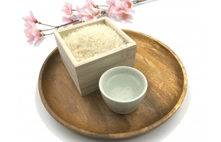 Arroz y sake en una cuenca, flores de cerezo al final