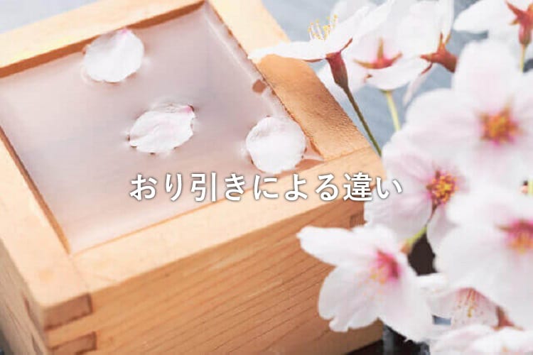 枡に並々とそそがれた日本酒の中に桜の花びらが入っている