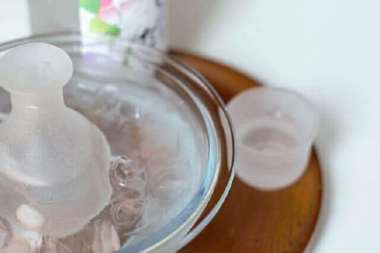 半透明の徳利とおちょこ(徳利は氷が入れられたボールに入れて冷やされている)