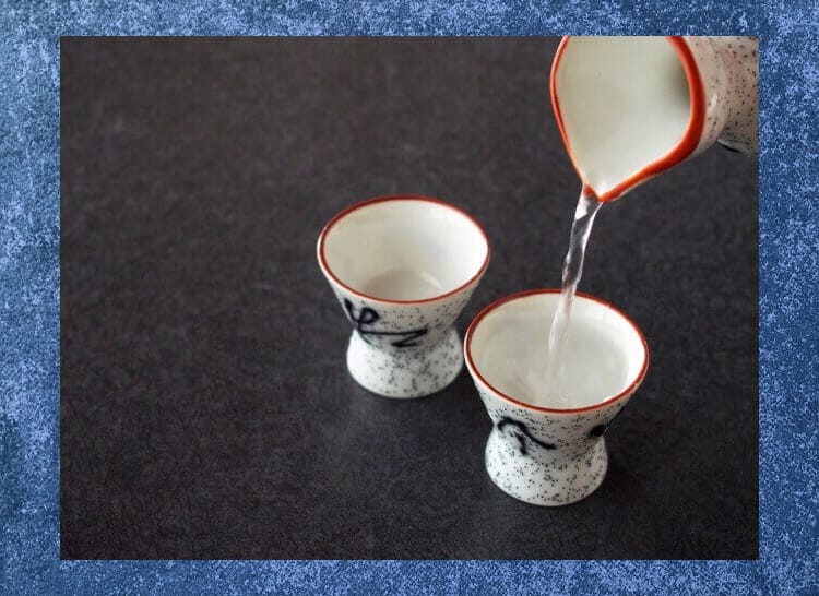 二つのおちょこに徳利で日本酒をつぐ