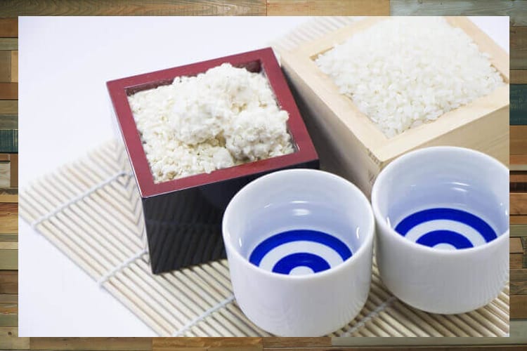 日本酒が入った二つのおちょことこちらも米が入った2つの枡
