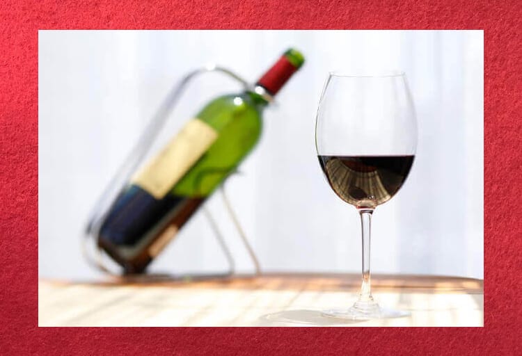 ワインのボトルとグラスに注がれた赤ワイン