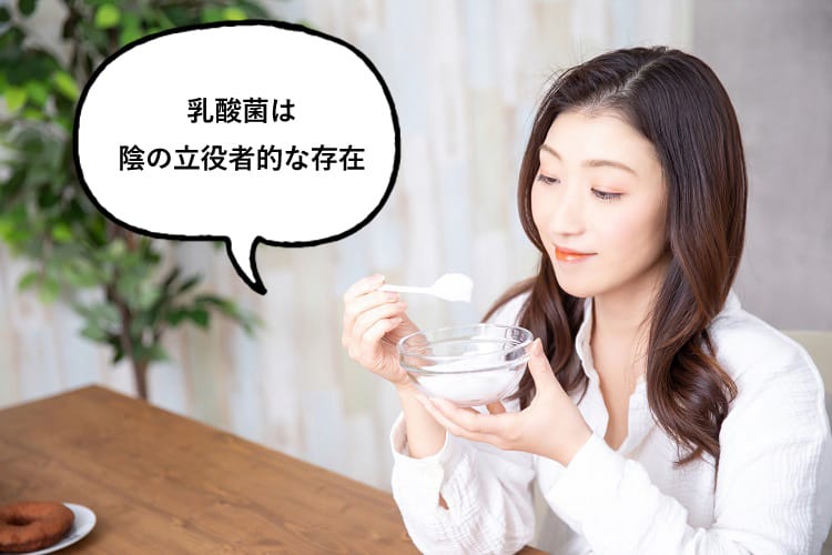 ヨーグルトを食べながら乳酸菌は影の立役者的存在と話す女性
