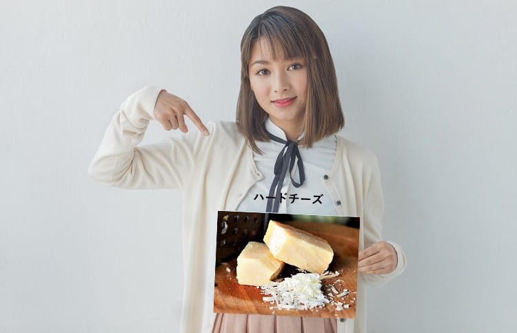 ハードチーズを指さす女性