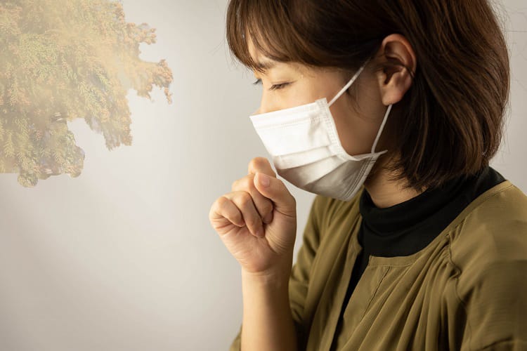 Kvinna som bär en mask som lider av pollen